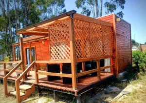 a small wooden house with a wooden deck at Cabaña Palmas de Tunquen in Tunquén