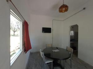 a dining room with a table and chairs and a window at Las Vertientes in Tanti