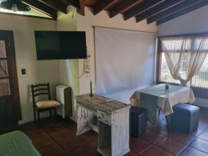 a room with a tv and a table and a chair at Cabaña Loft Los Grillos in Mar de Ajó