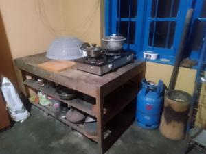 a kitchen with a stove with pots and pans on it at Sehandi Hotel - Arachchi Gedara in Ella