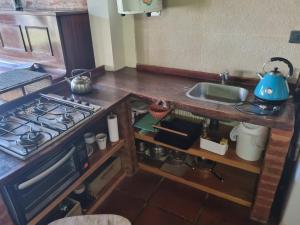 a kitchen with a stove and a sink at Cabaña Loft Los Grillos in Mar de Ajó +4 photos