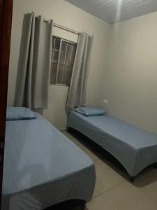 two twin beds in a room with a window at Casa da Villa Santa Rita in João Pessoa