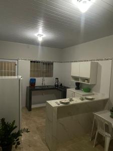 a large kitchen with a counter and a refrigerator at Casa da Villa Santa Rita in João Pessoa