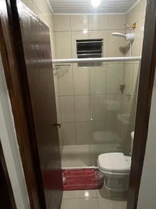 a small bathroom with a toilet and a shower at Casa da Villa Santa Rita in João Pessoa