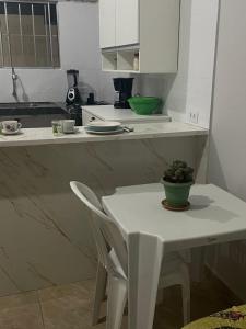 a white kitchen with a white table and a white chair at Casa da Villa Santa Rita in João Pessoa +4 photos