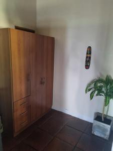 a room with a wooden cabinet and a potted plant at Cabaña Loft Los Grillos in Mar de Ajó