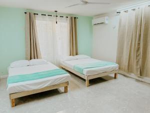 2 letti singoli in una camera con pareti blu di Depa 39 a Mérida