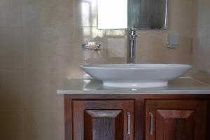 a bathroom with a white sink and a mirror at Ashasha Villa in Negombo