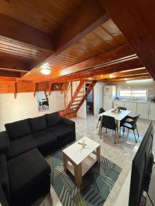 a living room with a black couch and a table at Cabañas Alpinas M&M in Perito Moreno
