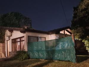 a house with a green tarp in front of it at Cabaña Loft Los Grillos in Mar de Ajó