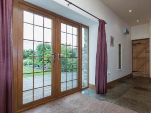 een lege kamer met een grote glazen deur bij Yr Hen Stabl in Tregaron +7 foto's
