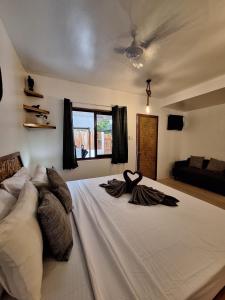 a bedroom with a large white bed with two towels on it at Tulog 1 in El Nido