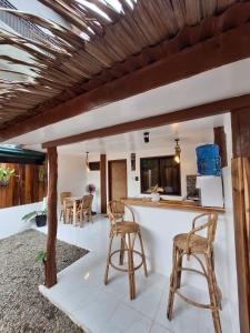 a kitchen and living room with a counter and stools at Tulog 1 in El Nido