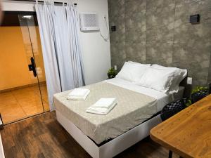 a bedroom with a bed with two towels on it at Pousada Verde Serrath - Muriqui in Vila Muriqui