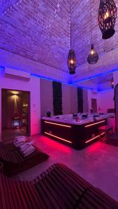 a room with purple lighting and a stage with tables at Rubino Private SPA & Room in Corato