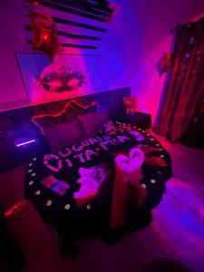 a bedroom with a bed with pink and purple lighting at Rubino Private SPA & Room in Corato +7 photos