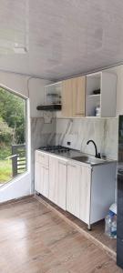 a kitchen with a sink and a stove at Supernova Glamping in Macanal