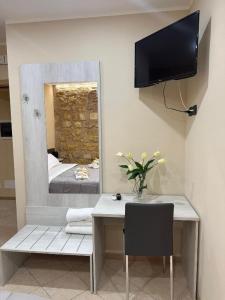 a room with a desk with a mirror and a television at Kalgheros in Agrigento