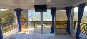 a bedroom with a bed and a tv and windows at Supernova Glamping in Macanal