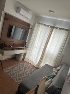 een slaapkamer met een bed en een raam met een televisie bij Aconchego Moro- Apto708, T-2 in Barra Velha