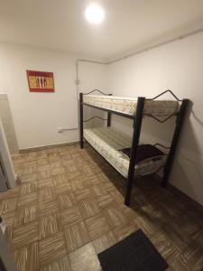 a room with two bunk beds and a wooden floor at Las Vertientes in Tanti