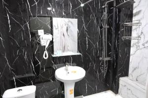 een badkamer met een wastafel, een toilet en een spiegel bij Amor Fati Hotel tashkent in Katartal