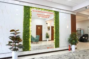 een lobby met een muur bedekt met groene klimop bij Amor Fati Hotel tashkent in Katartal +26 foto's