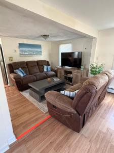 een woonkamer met een bank en een tv bij Oakland Beach Cottage - Sleeps up to 4 in Warwick