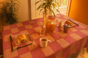 a table with a checkered table cloth with food and drinks at Hostel des 3 sources in Sainte-Marie