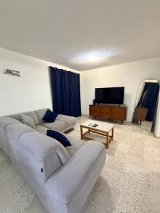 een woonkamer met een bank en een flatscreen-tv bij Comfortable ground floor apartment with 2 bedrooms in Villahermosa