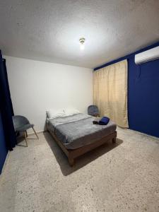 een slaapkamer met een bed en 2 stoelen. bij Comfortable ground floor apartment with 2 bedrooms in Villahermosa