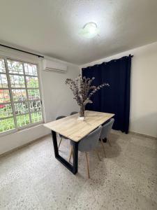 een eettafel met een vaas met bloemen erop bij Comfortable ground floor apartment with 2 bedrooms in Villahermosa +6 foto's