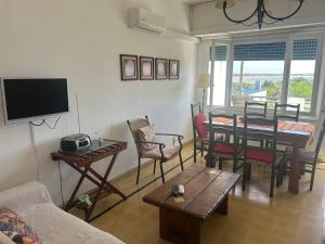 a living room with a table and chairs and a television at Irape in La Paloma