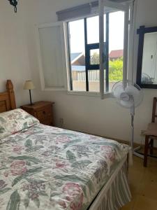 a bedroom with a bed and a window and a fan at Irape in La Paloma