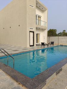 a swimming pool in front of a building at Horizon vue Villas in Rājahmundry