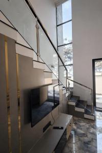 a staircase in a house with glass railing at Horizon vue Villas in Rājahmundry +2 photos