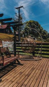 a bench sitting on a wooden deck with a sculpture at Chalés Refúgio nas montanhas in Guaratuba +37 photos