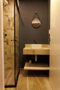 un bagno con lavandino e doccia di Lou Suites - 15 - Cantinho Charmoso a Guarapuava Altre 12 foto