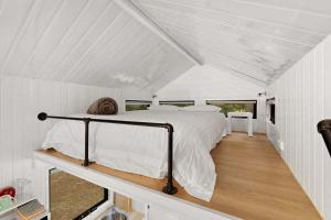 een slaapkamer met een bed in een witte kamer bij Celestial Haven by Tiny Away in Toolangi