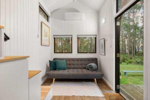 een woonkamer met een bank in een huis bij Celestial Haven by Tiny Away in Toolangi