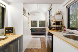 een keuken met een spoelbak en een woonkamer bij Celestial Haven by Tiny Away in Toolangi