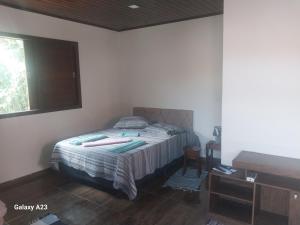 a bedroom with a bed in a room with a window at Morada do Sabiá - chalé 2 in Resende