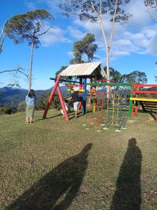 a group of people standing in front of a playground at Chalés Refúgio nas montanhas in Guaratuba