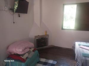 a small living room with a fire place in the corner at Morada do Sabiá - chalé 2 in Resende