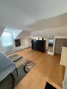 een woonkamer met een bed en een houten vloer bij Oakland Beach Cottage - Sleeps up to 4 in Warwick +8 foto's