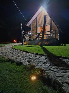 a log cabin at night with a stone path in front at Chalés Refúgio nas montanhas in Guaratuba
