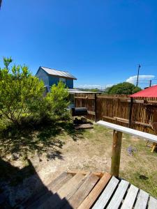 a wooden bench in a yard with a fence at TINY HOUSE Refugio de Mar in Mar del Plata
