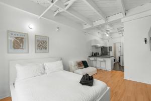 a white bedroom with a bed and a living room at Métropolitain Le Cachet in Quebec City
