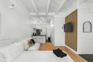 a living room with a white couch and a kitchen at Métropolitain Le Cachet in Quebec City