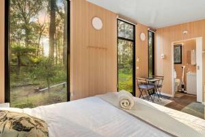 a bedroom with a bed and a large window at Quantum Field by Tiny Away in Toolangi